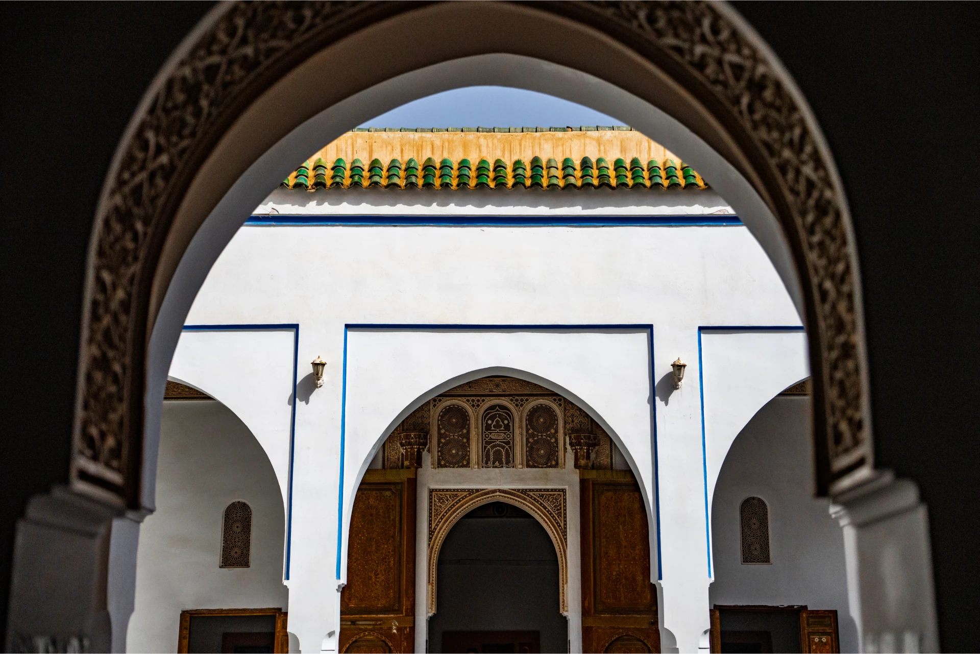 A carved archway framing an empty tiled courtyard