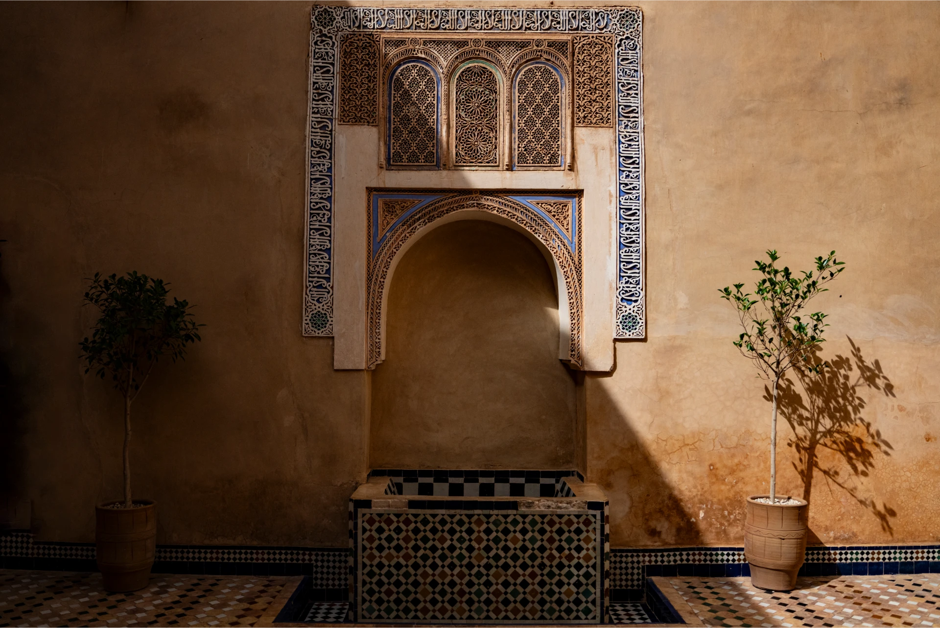 A quiet riad courtyard with a zellige fountain niche