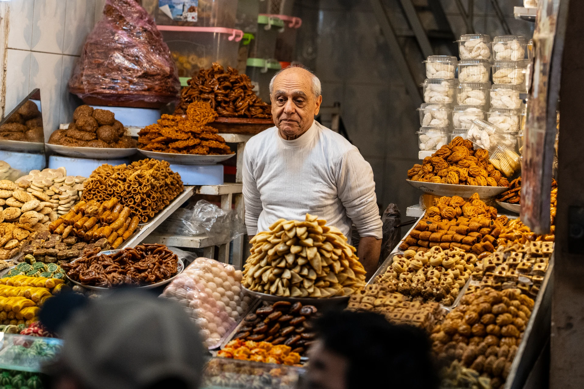 A vendor surrounded by dates and dried fruit at a Marrakech market stall