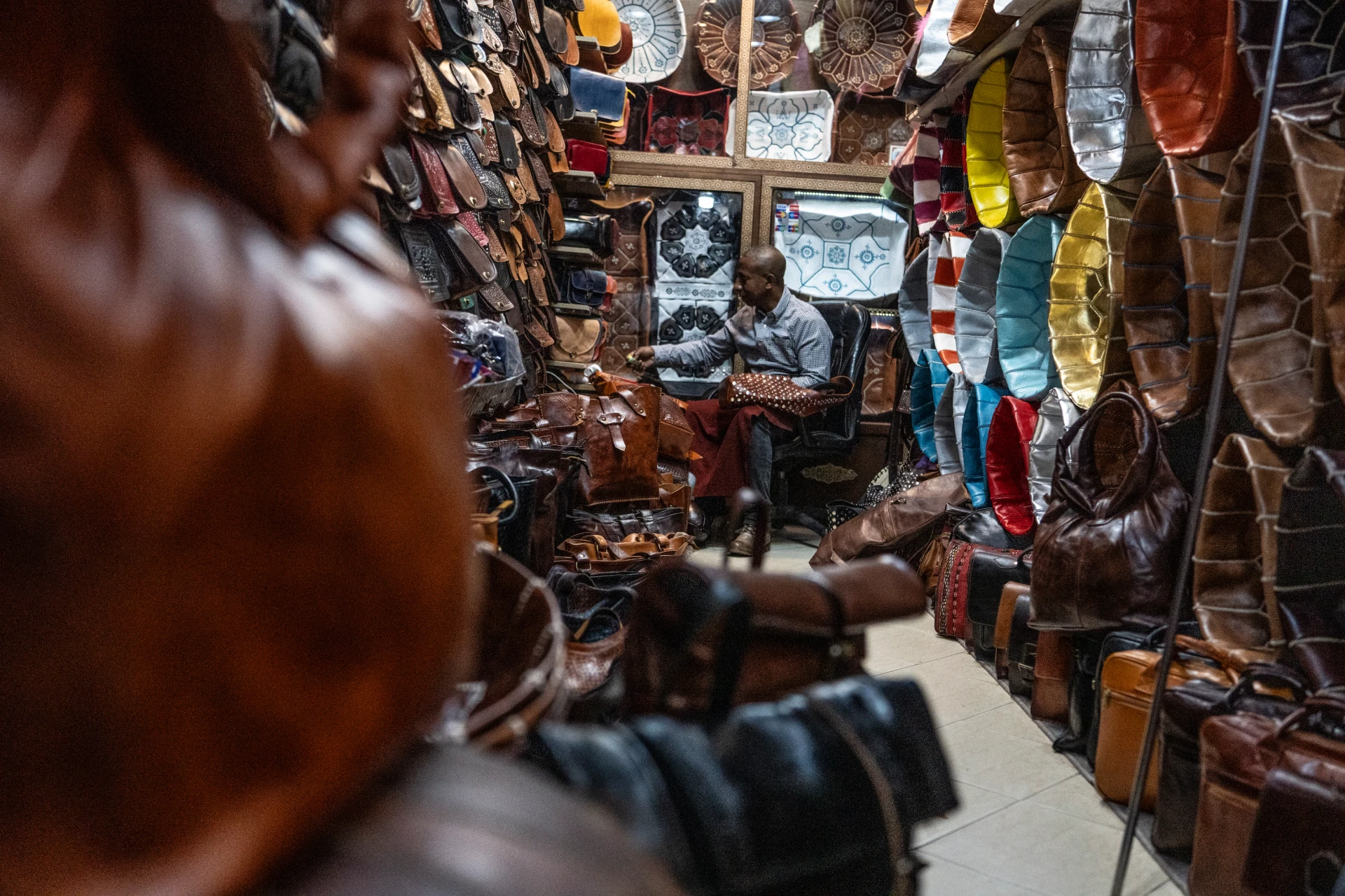 Colorful leather goods and lanterns hanging in a Marrakech souk lane