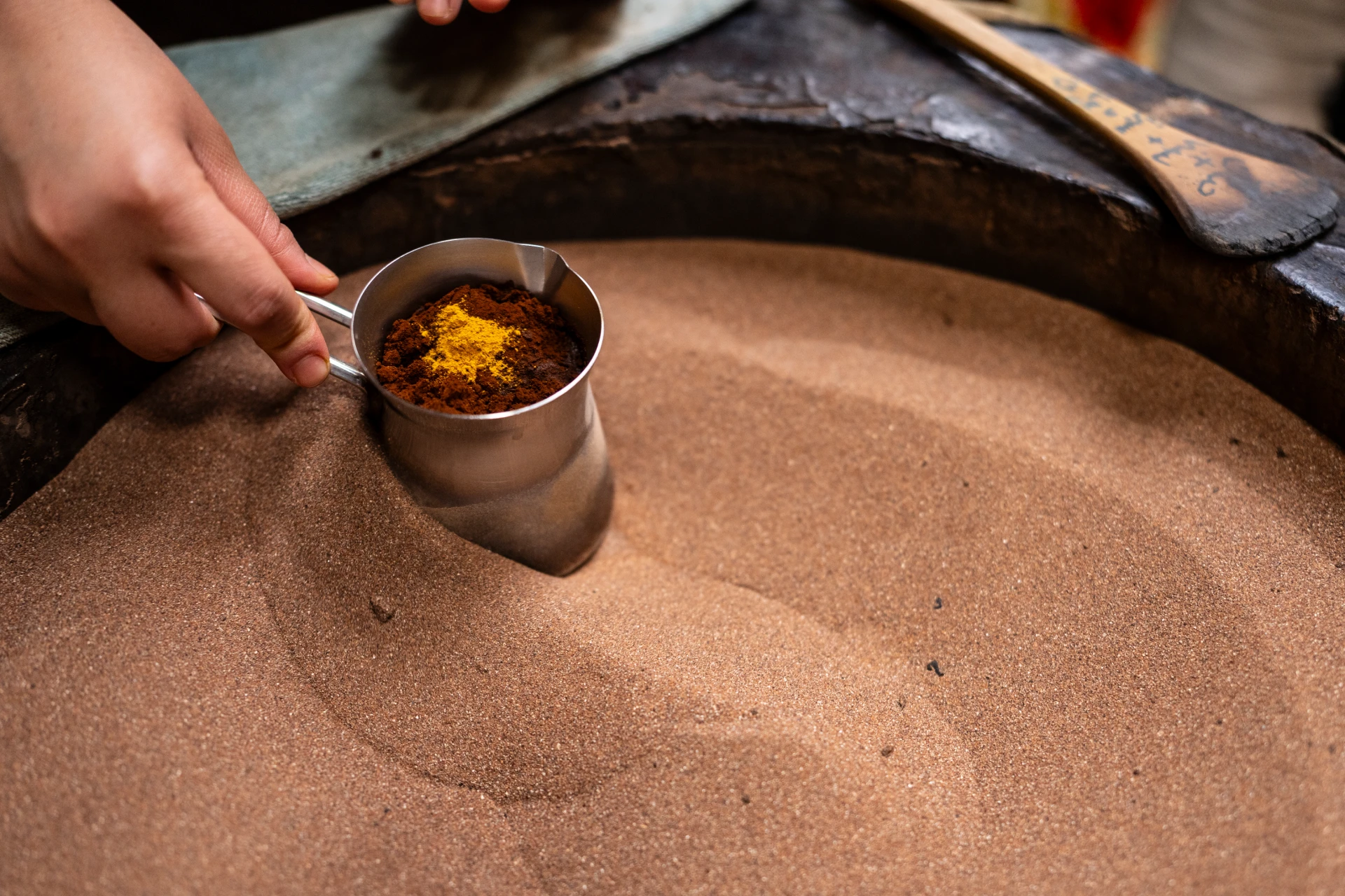 Coffee pots brewing in hot sand in a Marrakech souk