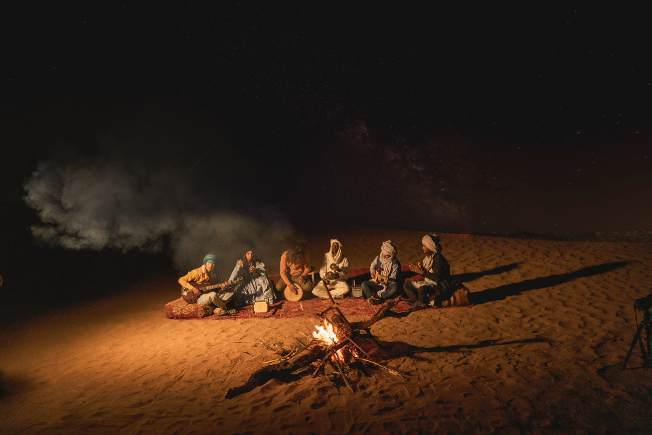 A campfire burning at a desert camp at night